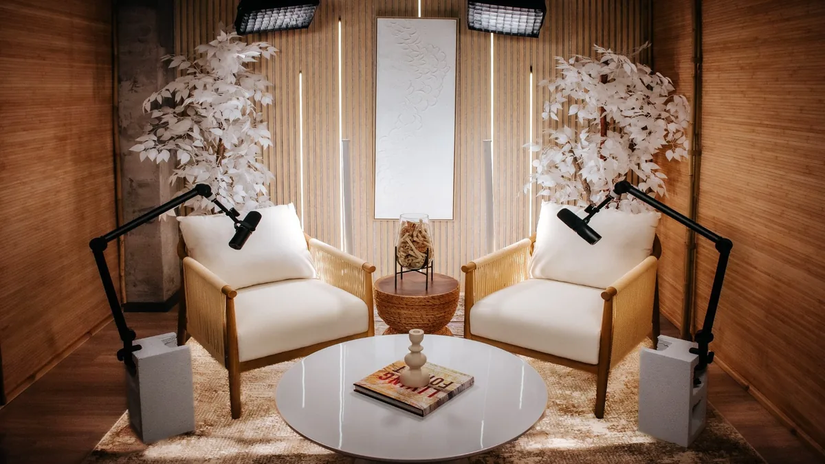 White Lotus studio with light wood, pale lounge chairs and sculptural greenery